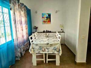 a dining room table with chairs and a tablecloth on it at Casa Conchita - Los Cancajos in Los Cancajos