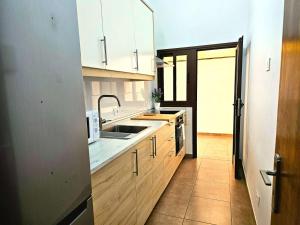 a kitchen with wooden cabinets and a sink at Casa Conchita - Los Cancajos in Los Cancajos