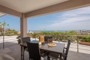 a table and chairs on a balcony with a view of the ocean at NeSo - Peter's Flat steps to Beach with Great Views in Kolymvari