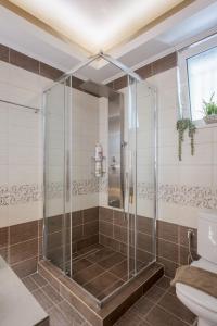 a glass shower in a bathroom with a toilet at NeSo - Peter's Flat steps to Beach with Great Views in Kolymvari +27 photos