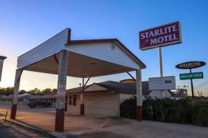 a shilling motel with a sign in front of it at Starlite Motel in San Antonio