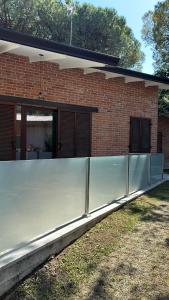een hek voor een bakstenen gebouw bij Villa Giny in Lignano Sabbiadoro +4 foto's