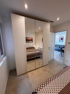een slaapkamer met een spiegelkast met een bed erin bij Villa Giny in Lignano Sabbiadoro