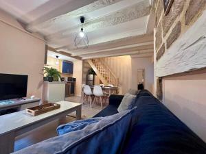 a living room with a couch and a tv and a table at Brive Republique in Brive-la-Gaillarde