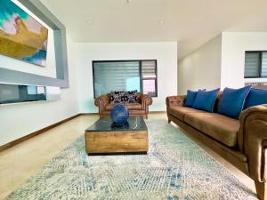 una sala de estar con un sofá y una mesa en Mar y Sol 16th floor Condo, en Rosarito