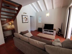 サン・フランソワにあるVilla Alizée charmante villa avec piscineのソファとテレビのあるリビングルーム