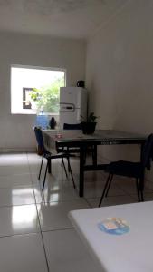 a living room with a table and a refrigerator at C&R hostel residência in Salvador