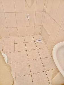 a bathroom with a sink and a tiled floor at Shanzu Pride Studio Apartment Mombasa in Mombasa
