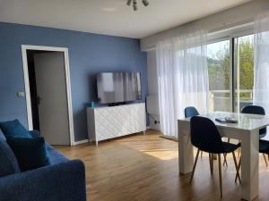 a living room with a table and a blue wall at Domaine des Roches in Trouville-sur-Mer