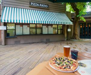 a pizza sitting on top of a table with a drink at Curry Village in Curry Village