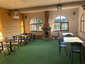 a dining room with tables and chairs and a fireplace at Pod Bocianim Gniazdem in Ropienka