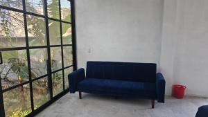 a blue couch in a room with a large window at casaroja in Palenque