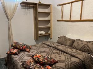 a bed with pillows on it in a room at VILLA "MYKONOS" pour vos moments de détente en famille piscine privative, 3 chambre climatisées, salon climatise télé machine a laver cuisine, jardin arbore gardien parking 100 m de la plage in Ngaparou +34 photos