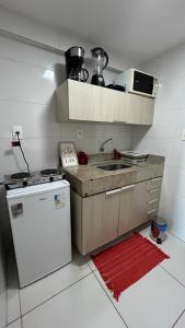 a small kitchen with a sink and a refrigerator at Flat Tambaú - Beira-mar in João Pessoa