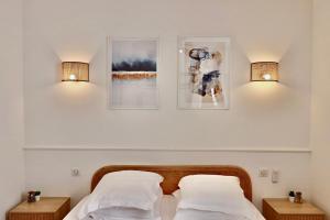dwa łóżka w sypialni z dwoma światłami na ścianie w obiekcie FERSEN Superb Mediterranean style apartment in heart of Old Antibes w mieście Antibes