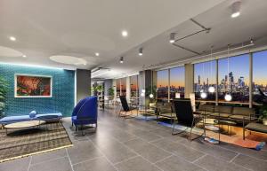 霍博肯Exclusive 1BR Apt with NYC View and Pool的大厅配有桌椅，可欣赏城市景观