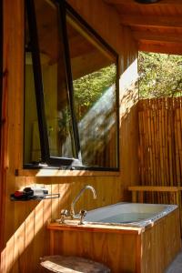 a bath tub in a room with a window at Increíble cabaña, naturaleza, a 300m del mar, Pinamar in Pinamar