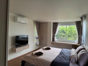 Un dormitorio con una cama y un televisor de pantalla plana. en Nový 3-spálňový apartmán v centre Lamai, en Nathon Bay