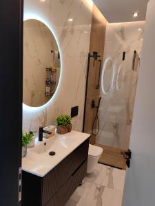 a bathroom with a sink and a toilet and a mirror at Luxury Panorama View with a Pool in Sarandë +46 photos