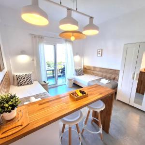 a living room with a wooden table and a bed at Villa Thalassa Apartments in Pefkochori