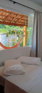 a bedroom with a window and a white bed at Casa da Flor in Morretes