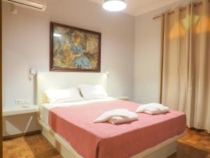 una camera da letto con un letto e un dipinto sul muro di Orchid 3 Bedroom Suite Kastraki a Kastraki