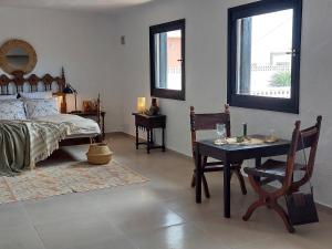 a bedroom with a table and a bed and a window at Apartment La Casa Blanca in Playa del Hombre
