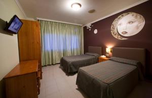 A bed or beds in a room at Hostal Restaurante Terra Chá