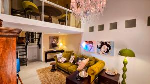 a living room with a green couch and a chandelier at Taunusgarten in Bad Camberg