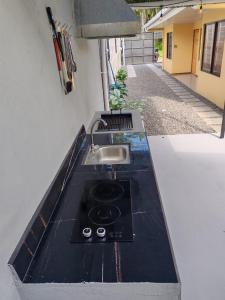 a kitchen counter with a sink and a sink at Bandera Beach Cabins in Parrita +11 photos