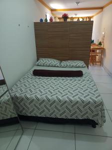 a bed in a bedroom with a wooden headboard at Aconchego da Kika in Caruaru