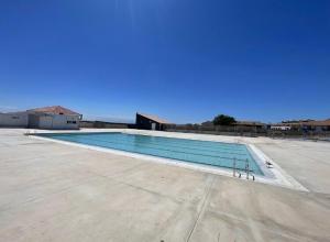 a large swimming pool in a parking lot at Lake view apartment with pool in Le Barcarès