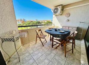 a patio with a table and chairs on a balcony at Lake view apartment with pool in Le Barcarès