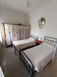 a room with three beds and a mirror at La "Casina nel borgo" , relax a un passo dalle 5 Terre in Merizzo