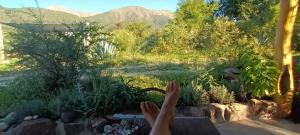 een persoon met zijn voeten op een tafel en kijkend uit een raam bij La calendula eco cabaña in Los Hornillos