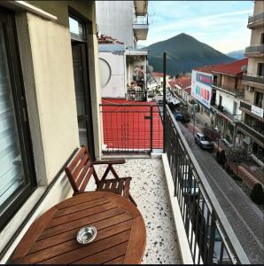 a balcony with a wooden bench and a view of a city at Down Town Karpenhsi in Karpenision