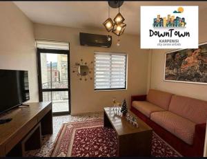 a living room with a couch and a tv at Down Town Karpenhsi in Karpenisi