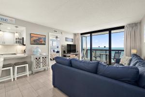 un salon avec un canapé bleu et une cuisine dans l'établissement GS 2008 - Seaside Haven, à Ocean City