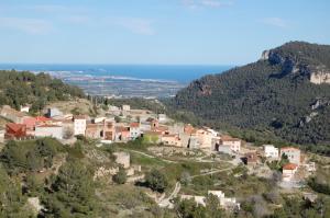 a village on a hill with trees and houses at Rural Colldejou Cal Caterí in Colldejou