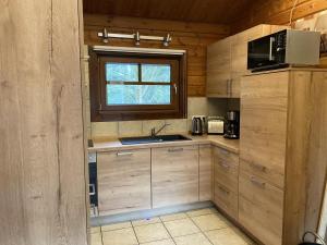 a kitchen with wooden cabinets and a sink and a window at Ferienhaus-Kaninchenhoehle in Haren