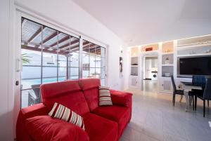 a living room with a red couch and a television at VillaSue in Tías