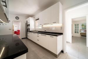 a kitchen with white cabinets and a black counter top at VillaSue in Tías