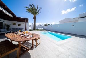 a patio with a table and a swimming pool at VillaSue in Tías