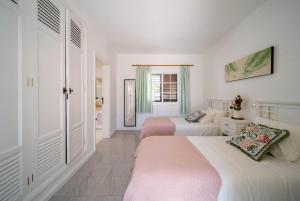 two beds in a room with white walls at VillaSue in Tías +13 photos