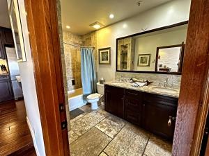 a bathroom with two sinks and a toilet and a mirror at Ocean View Retreat W Pool Access in Avalon