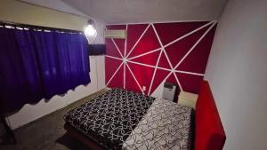 a bedroom with a bed with a red and purple wall at LUSANYUN in Villa Carlos Paz +6 photos