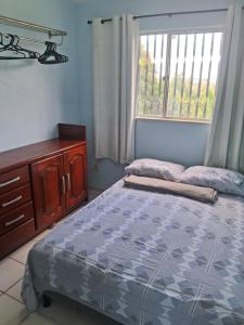 a bedroom with a bed and a dresser and a window at O melhor Custo Benefício São Luiz MA AP1 in São Luís