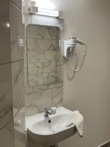 a bathroom with a white sink and a mirror at Le Montclair Montmartre by River in Paris +34 photos