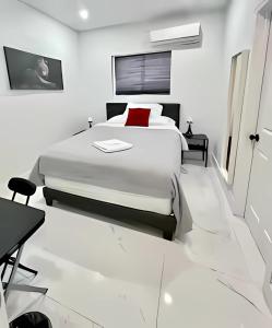 a white bedroom with a large bed and a desk at Cute Private Room - Close to airport & Free parking 01 in Miami