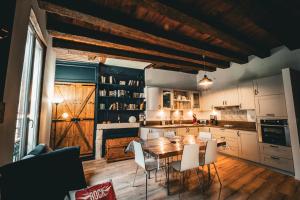 a kitchen with a wooden table and white chairs at Appart typique cœur de ville in Bergerac +13 photos